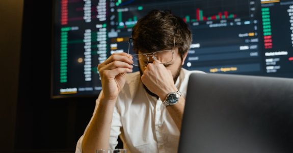 a-stressed-man-looks-at-stock-market-data-on-his-computer-screen-in-an-office-setting